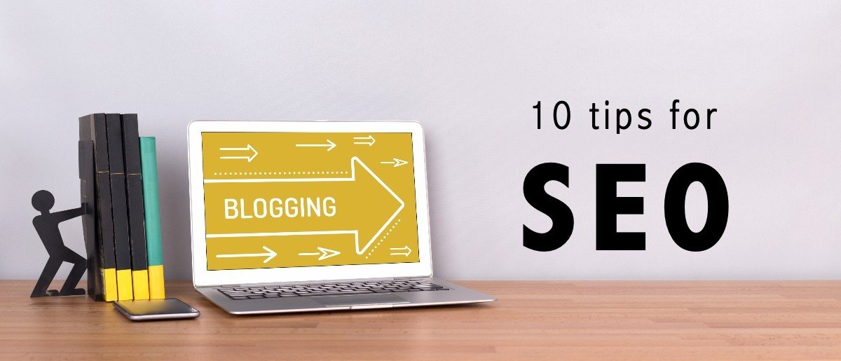 Helt til venstre står noen bøker på en pult. LItt til høyre står en laptop med en pil der vi kan lese "blogging". Pilen peker til høyre der vi ser teksten "10 tips for SEO".